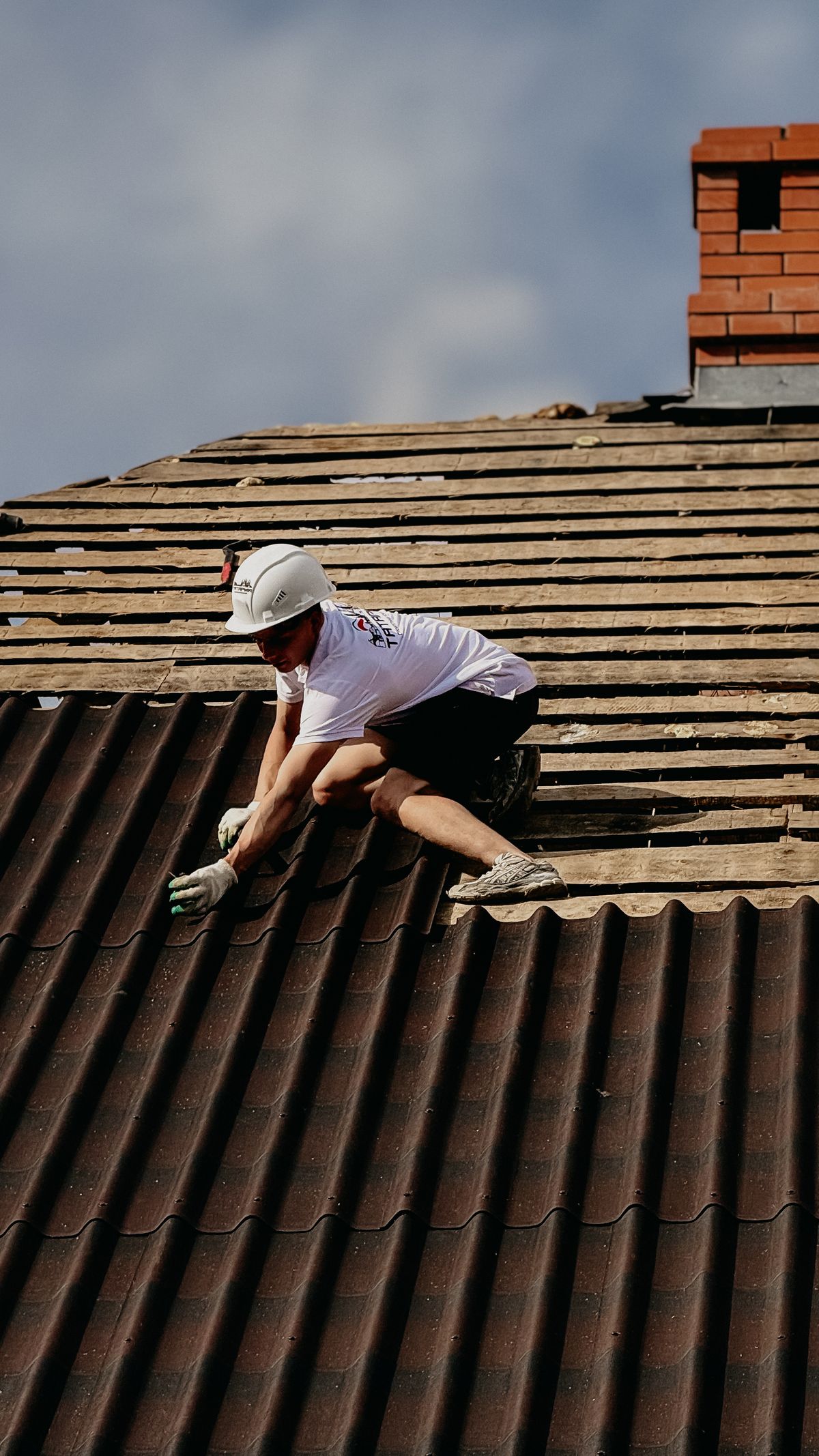 Couvreur posant des tuiles sur une toiture en Essonne